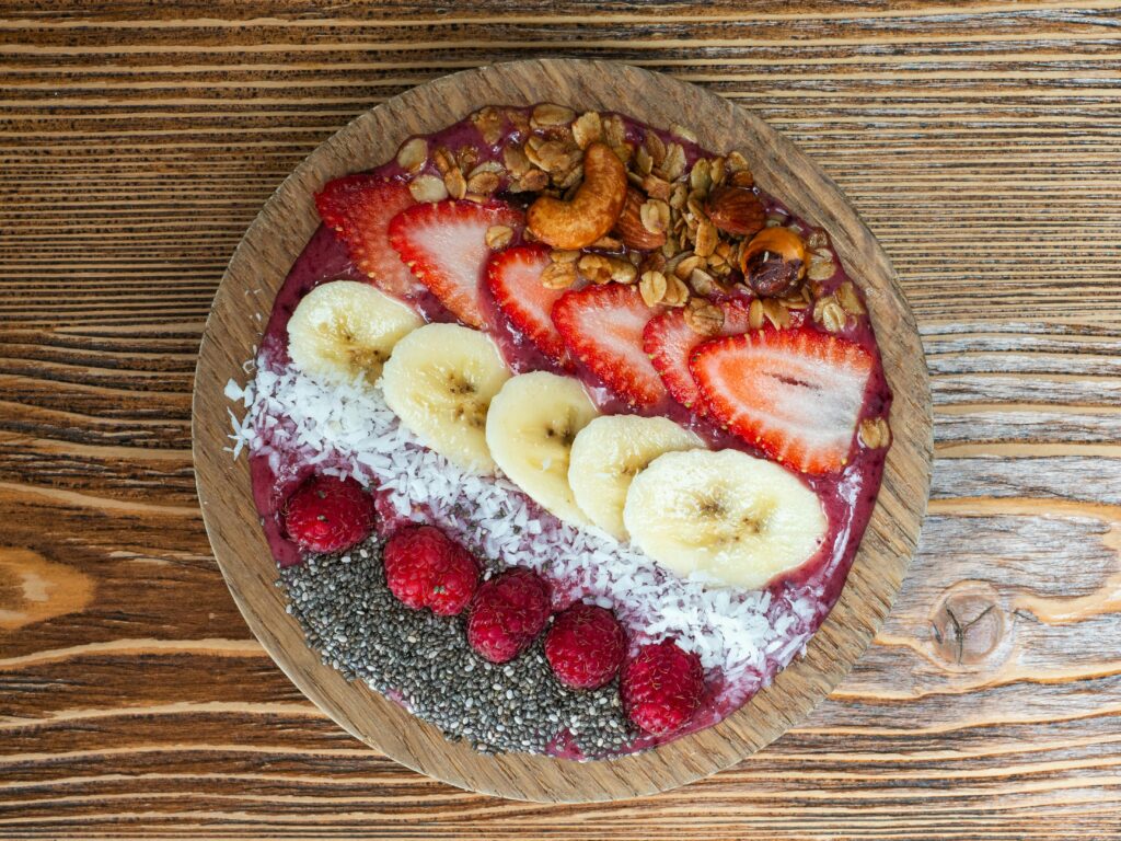 A vibrant spread of fresh fruits, whole grain toast, and a smoothie bowl