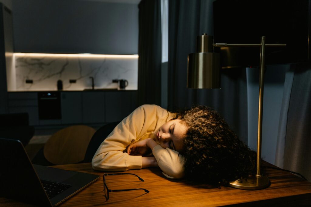Weary worker hunched over a desk late at night
